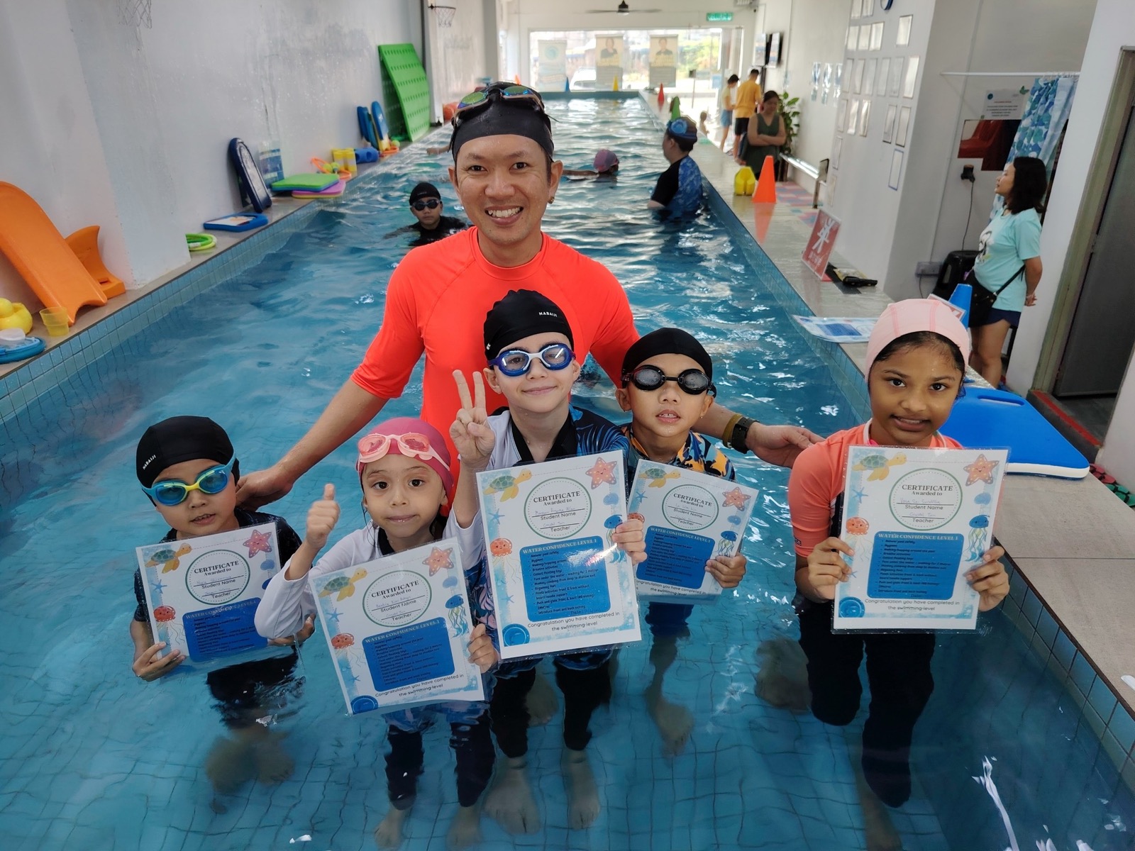 Founder Coach Jasper with proud young swimmers holding their Water Confidence certificates